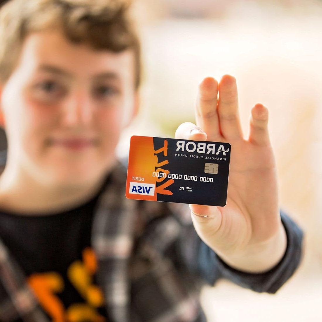 Boy holding Arbor Volt Visa Card